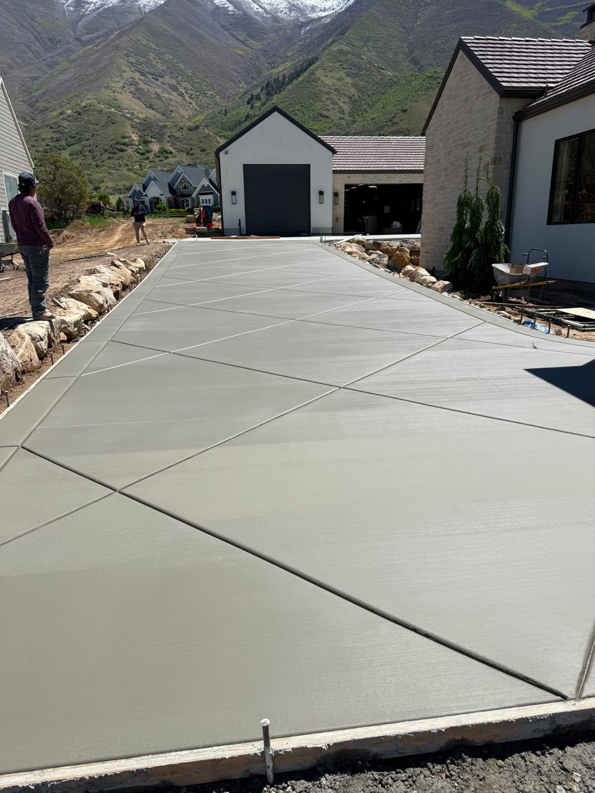 Diamond-scored concrete driveway with mountain backdrop